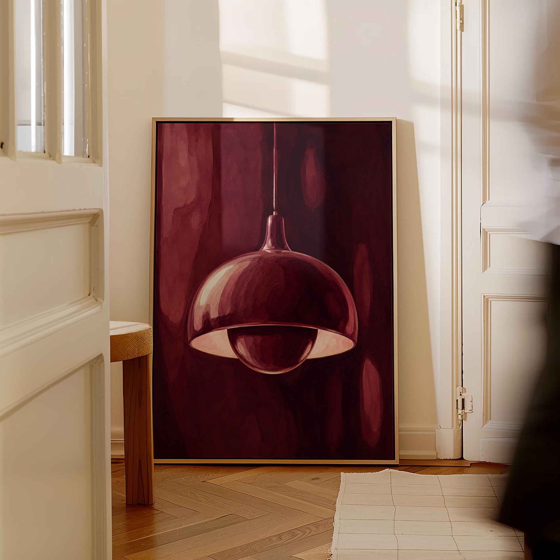 Pendant lamp glowing warmly against burgundy darkness, canvas wall art presented in a light, minimal room