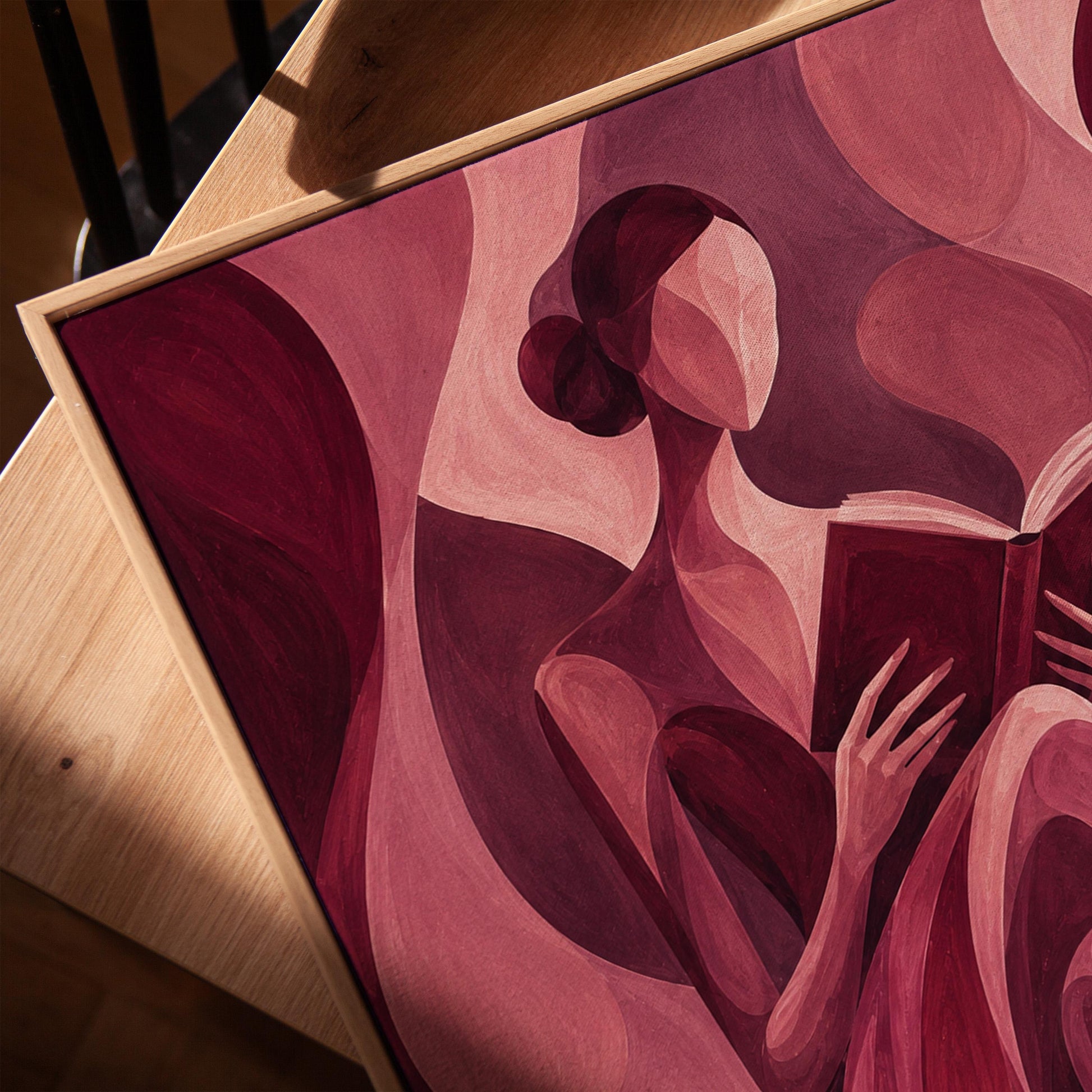 Woman reading a book among flowing burgundy drapes, canvas print in a warm, minimally styled interior
