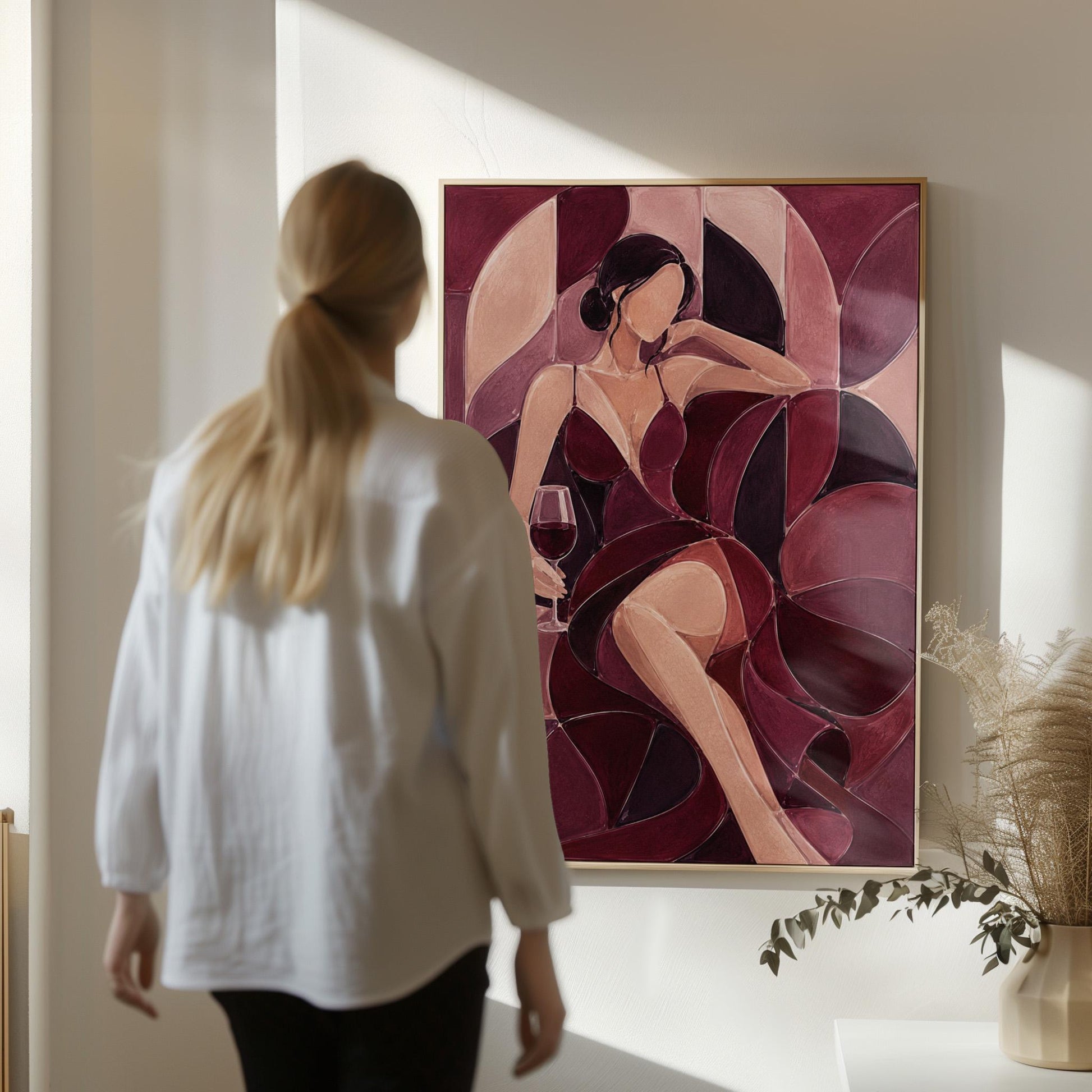 Woman lounging with wine glass in burgundy deco, canvas wall art hanging in a calm, modern living space