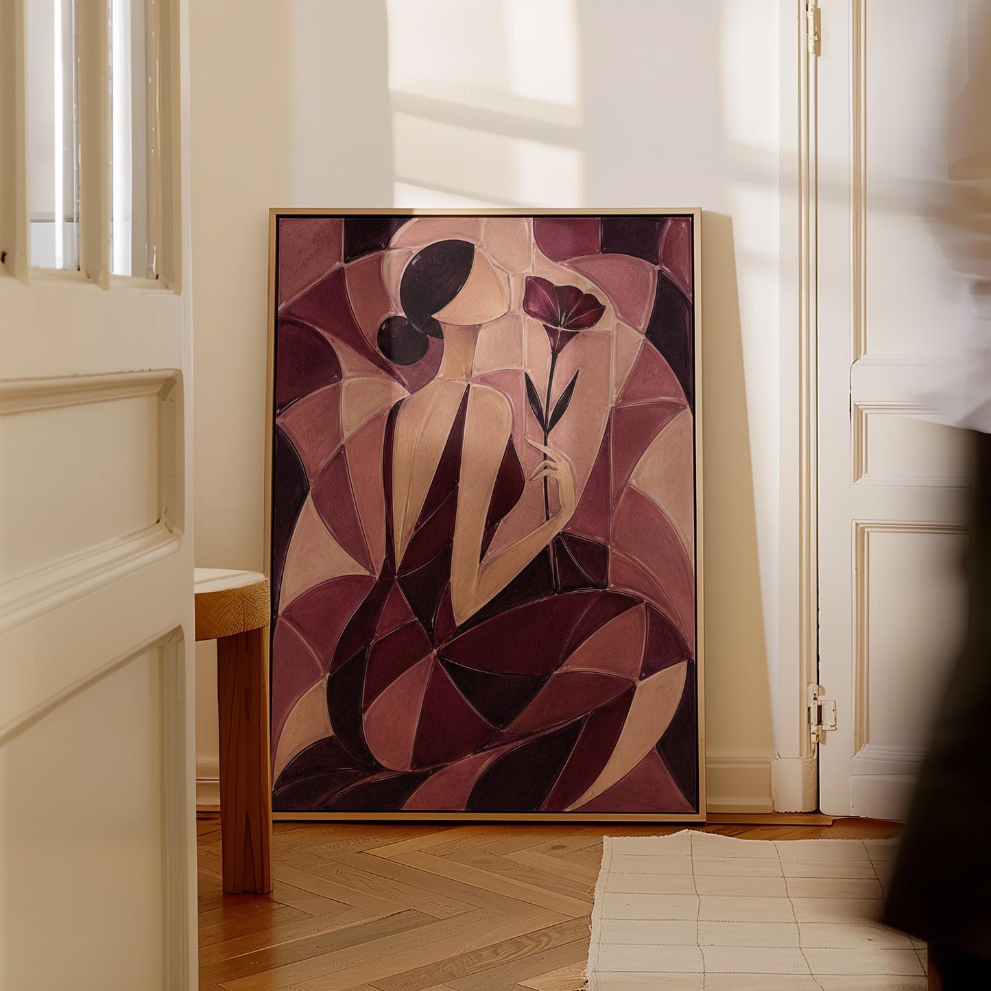 Woman holding poppies in cubist burgundy and cream, canvas wall art presented in a light, minimal room