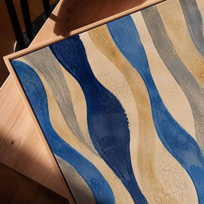 Vertical flowing wave bands in indigo and cream, canvas print in a warm, minimally styled interior