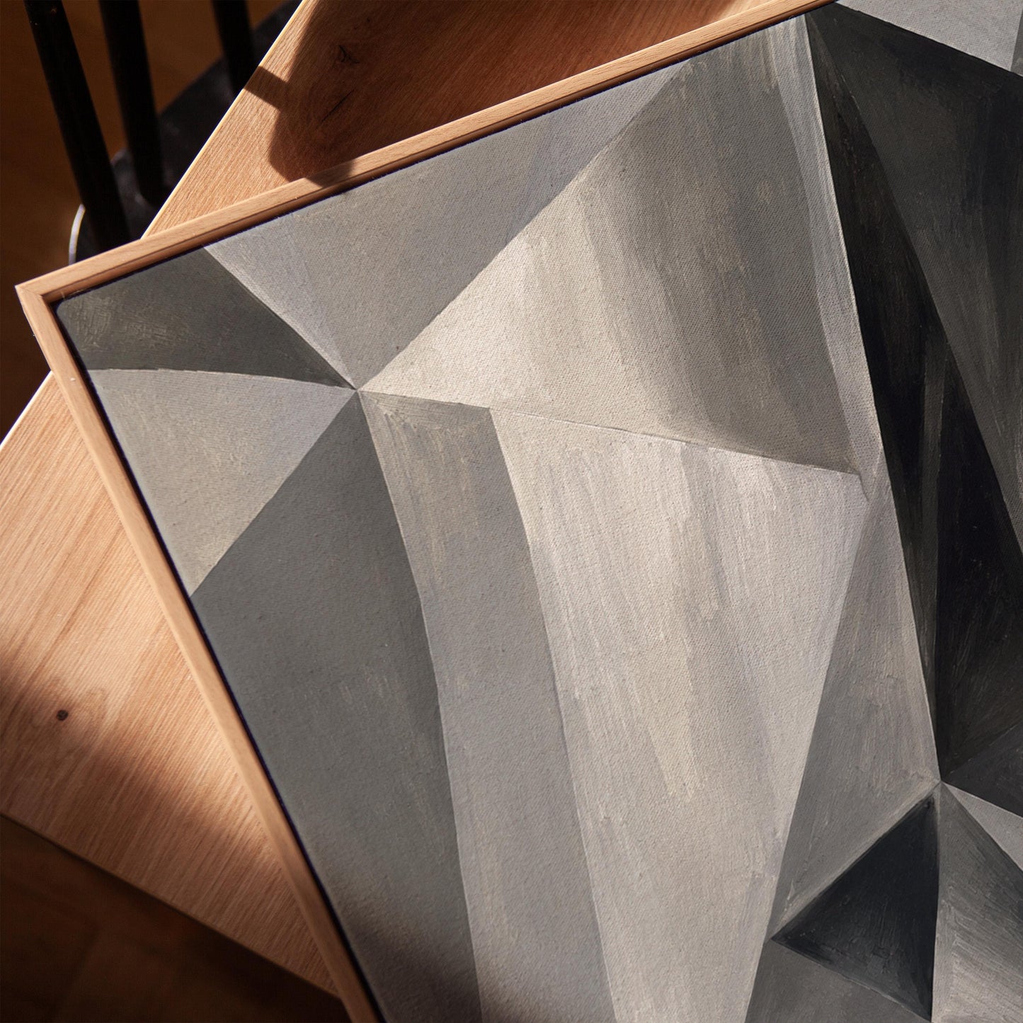Angular graphite planes with sharp light play, canvas print in a warm, minimally styled interior