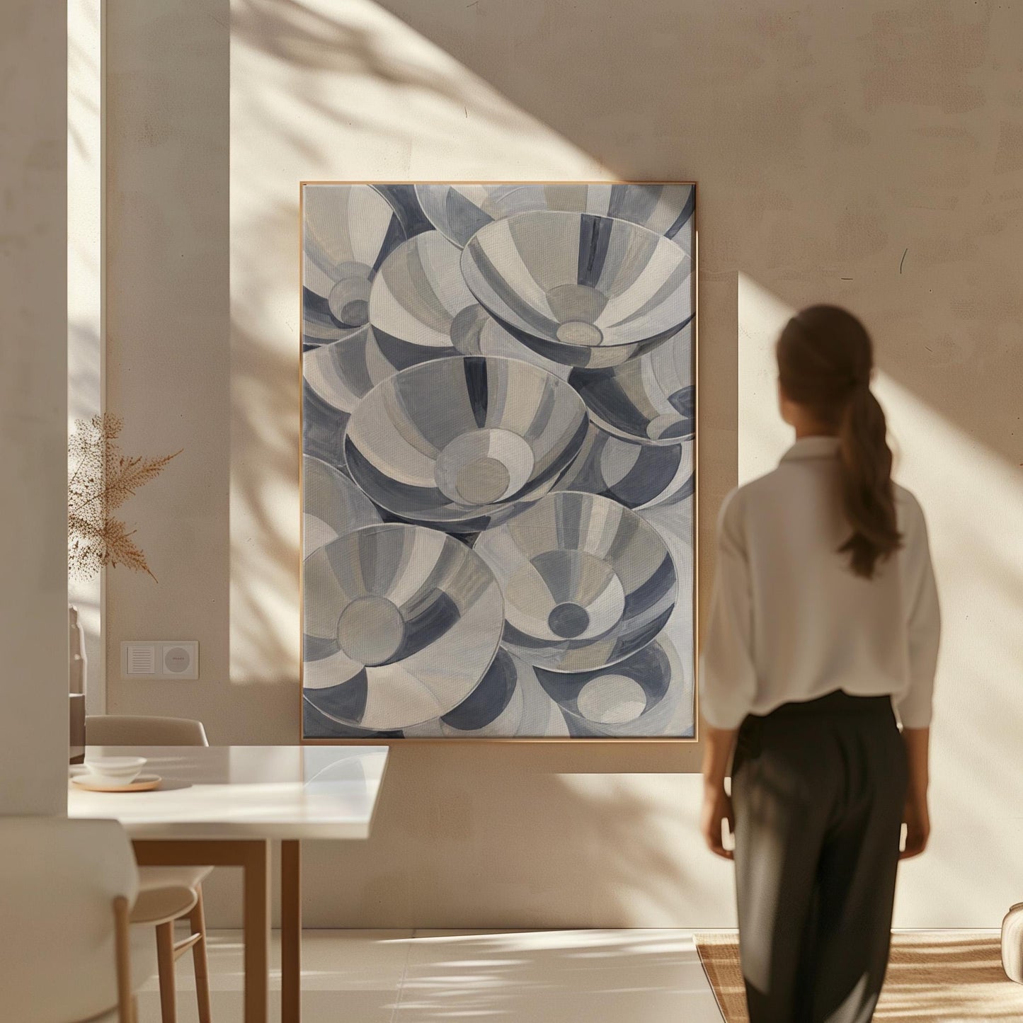 Nested silver bowl curves overlapping rhythmically, canvas print hanging in a calm, modern living space
