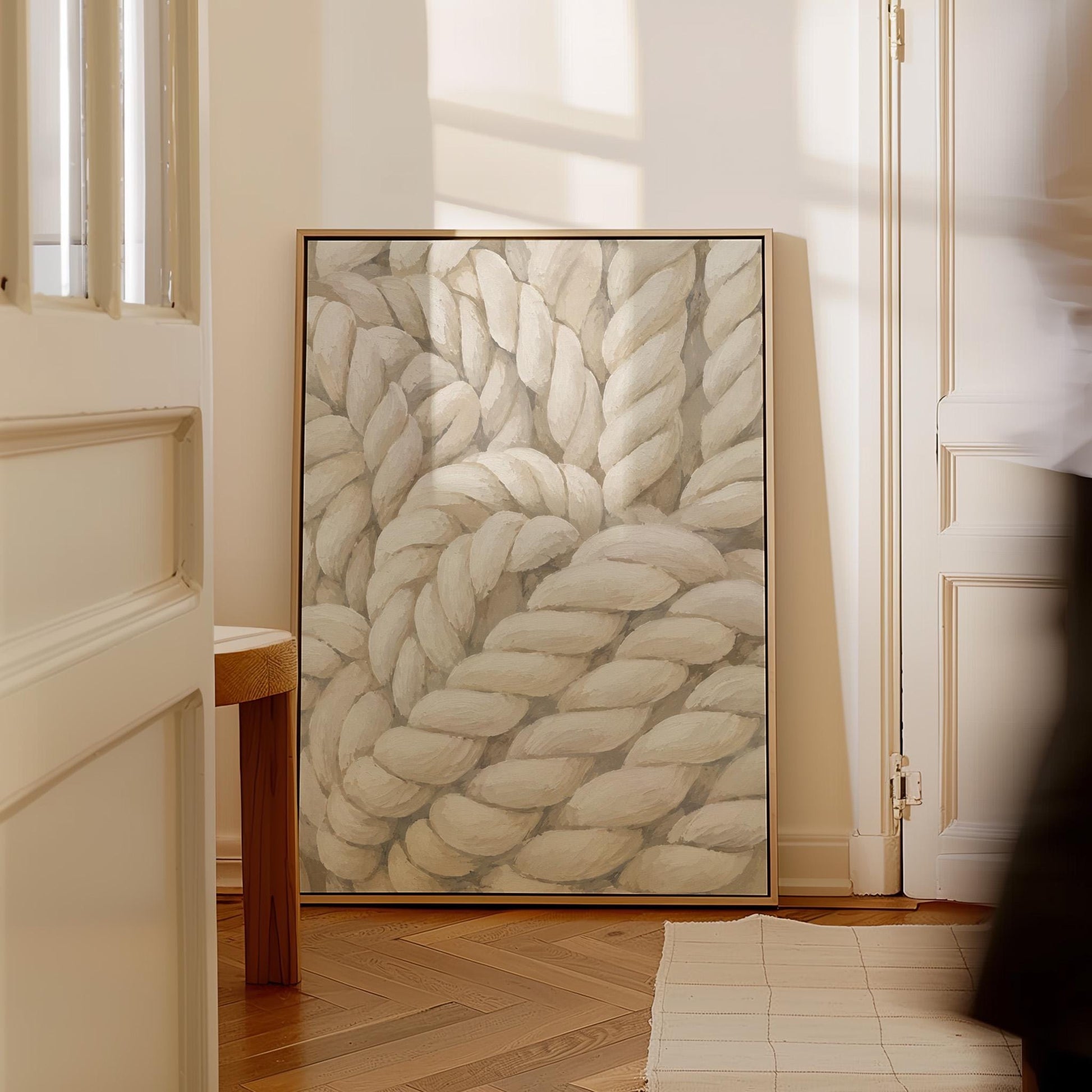 Thick cream ropes twisted into a knot, canvas print hanging in a calm, modern living space