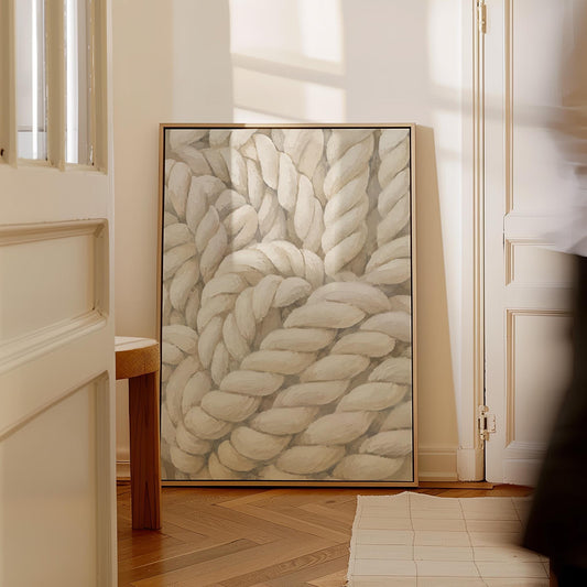 Thick cream ropes twisted into a knot, canvas print hanging in a calm, modern living space