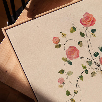 Single rose with trailing vine in slim vase, canvas print in a warm, minimally styled interior