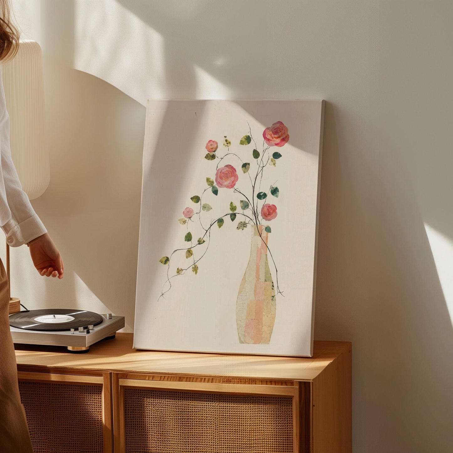 Single rose with trailing vine in slim vase, canvas wall art seen in a warm interior with natural light